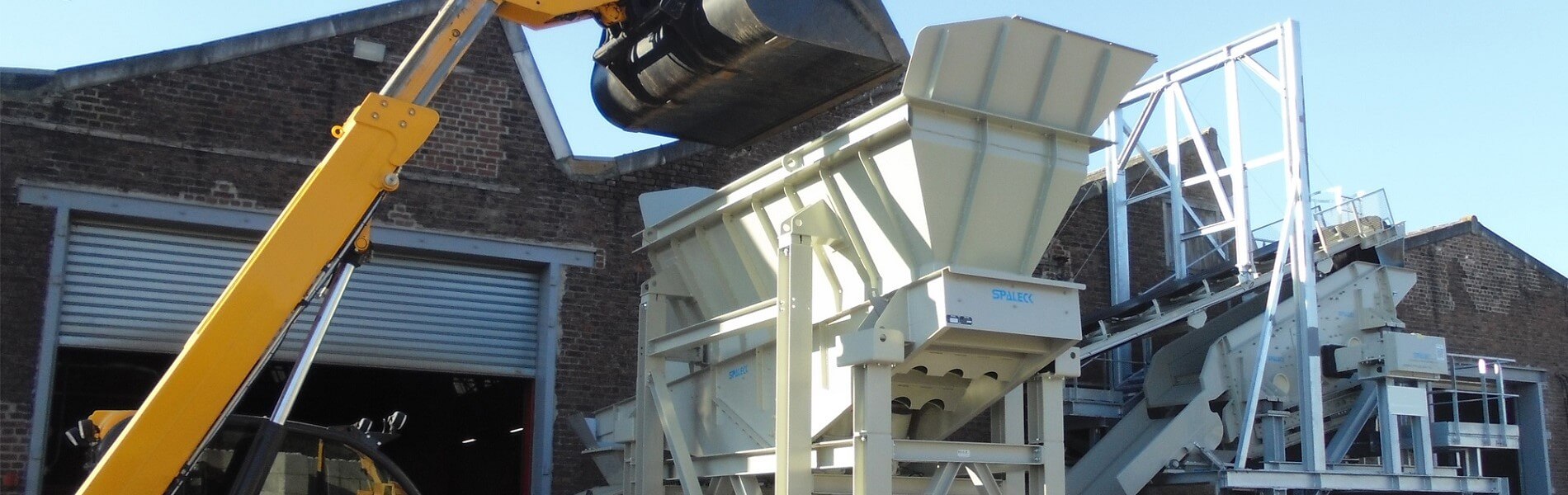 Load of a feed hopper on site at a recycling plant